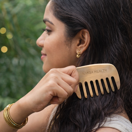 Hand holding Kansa Bronze Head Massage Comb for Ayurvedic Scalp Therapy